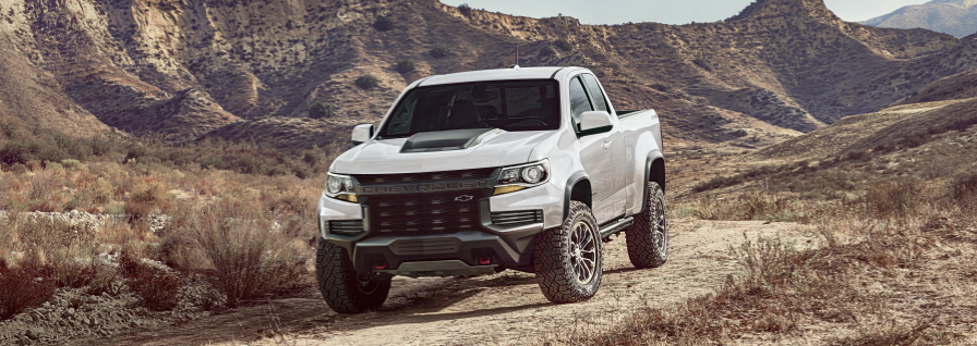 GM white truck outside construction building